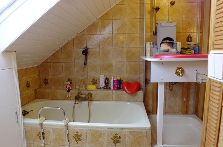 Blick in ein altes Bad mit Badewanne