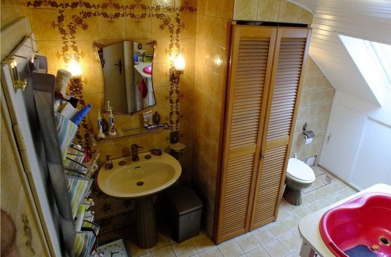 Foto einer Badezimmers im Stile der 70er, mit einem Waschtisch, Schrank und Toilette.