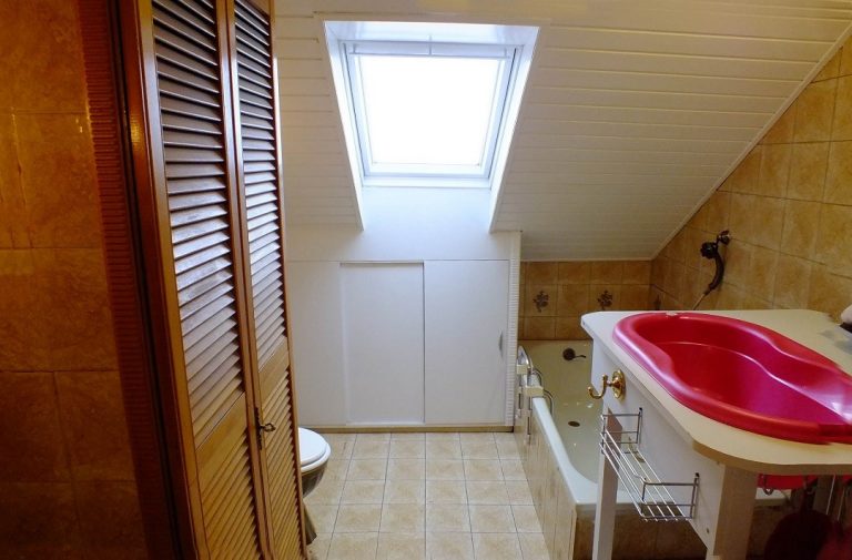 Blick in ein Badezimmer mit Dachschräge und Badewanne